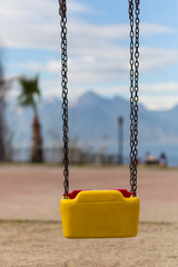 Empty swing with yellow and red colors