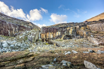 Naklejka premium Old stone quarry with waterfall in Mourne Mountains near Slieve Donard mountain. This mountain range is highest and most dramatic in Northern Ireland