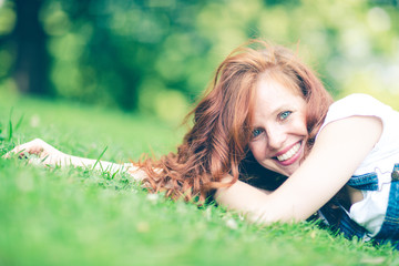 young woman lying on grass