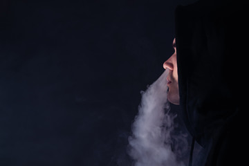 man in the clouds of steam from electronic cigarette closeup. vaping man