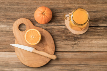 glass of fresh orange juice and oranges on cutting board
