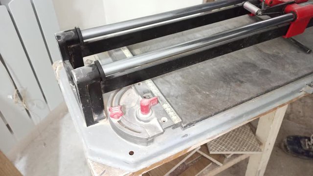 Worker cuts tiles with tile to be installed on the floor