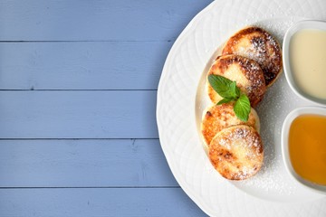 Stack of small pancakes with syrup on plate