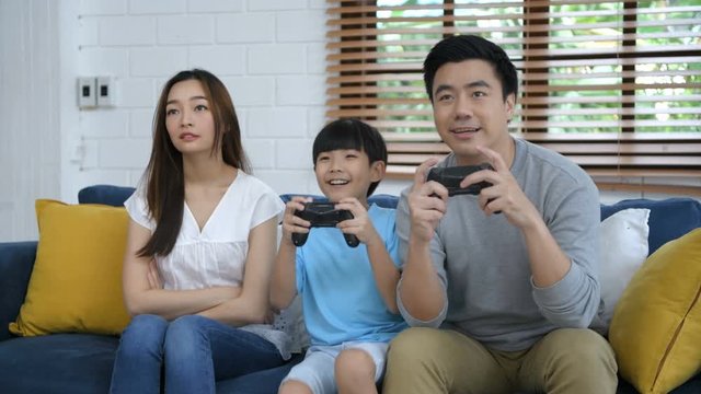 Family concept. Father and mother are playing games with their son in the living room. 4k Resolution.