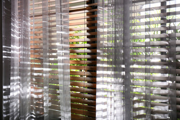 Window with beautiful curtains and blinds, closeup