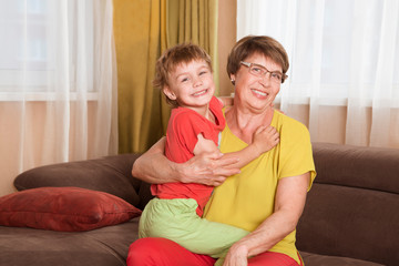 Happy middle-aged mature grandma and  little  grandson having fun playing at home