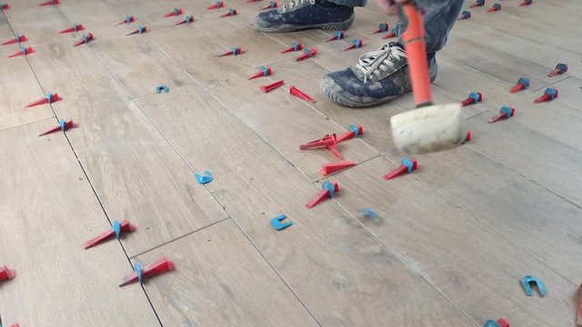 The tiler applies glue and puts the tiles