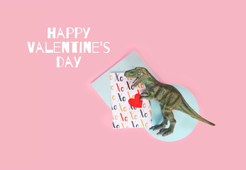Happy Valentine's day. Dinosaur with red heart on pink background. funny minimal concept. shallow...