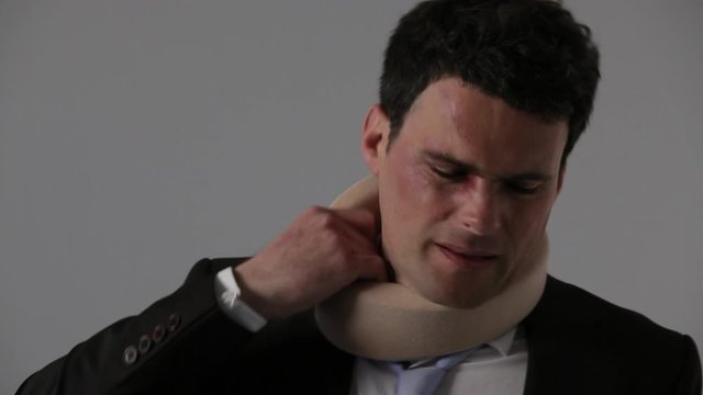 CU, Lockdown, Bruised businessman removing a neck brace