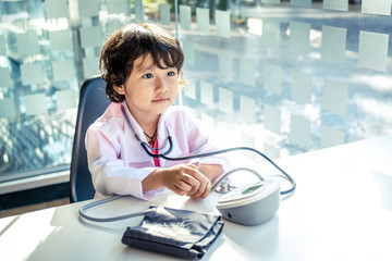Photo of kid doctor with stethoscope working in the office