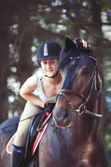 Obraz premium Black horse portrait with cheerful teenage girl equestrian