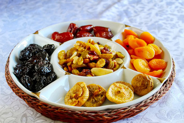 Jewish holiday Tu Bishvat. Traditional jewish food in Israel, Dried fruits and nuts. Apricots, Prunes, Dates and Raisins in a glass tray