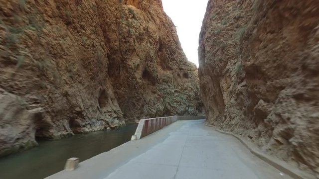 Tracking shot of narrow road amidst rocky mountains, Dad&egrave;s Gorges, Morocco