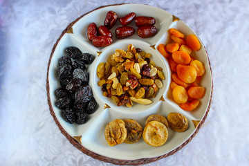 Jewish holiday Tu Bishvat  in Israel. Traditional jewish food, Dried fruits and nuts. Apricots, Prunes, Dates and Raisins in a glass tray