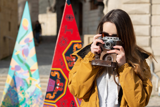 Photo of young tourist girl exploring streets of Baku. Moody photos of teenager girl visiting old city and taking photos of the city
