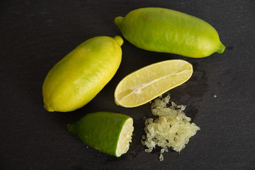 finger lime tagliati, su tagliere scuro