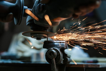 angle grinder is cutting metal with sparks close up