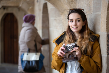 Fototapeta na wymiar Photo of young tourist girl exploring streets of Baku. Moody photos of teenager girl visiting old city and taking photos of the city