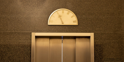Detail of an elevator door with moving pointer on a vintage floor level display © Felix Busse Phtgrphy