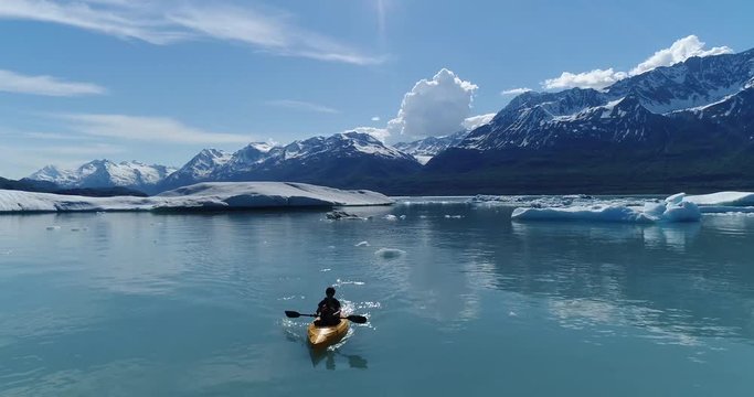 Woman kayaking in water against snowcapped mountains, Alaska, USA