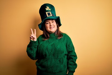 Young beautiful plus size woman wearing green hat with clover celebrating saint patricks day...
