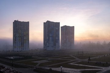 Naklejka na ściany i meble morning heavy fog or forest fire smoke against the multi-storey apartment skyscrapers