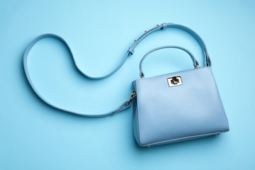 Stylish woman's bag on light blue background, top view