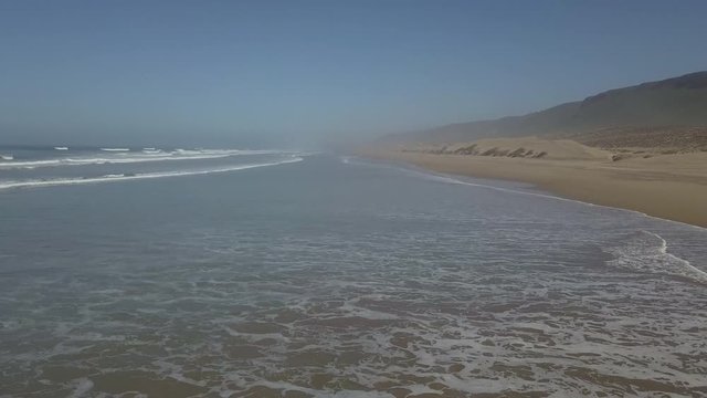 Drone shot of sea waves at beach against clear blue sky, Sidi Ifni, Guelmim-Oued Noun, Morocco