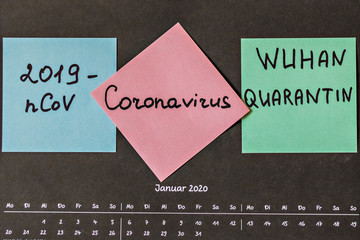 Calendar page with the word January in German on the wall with notes in English with the words "Coronavirus","2019-nCoV" and "Wuhan Quarantine".  Chinese outbreak of coronavirus.