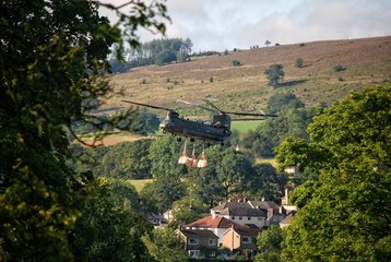 Chinook helicopter carrying bags of ballast in Whaley Bridge, Peak District