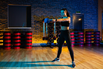 Obraz premium Fit young woman workout in the gym with kettlebell.