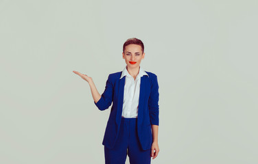 Look here. Businesswoman presenting the copy space isolated light green white office wall background. Short hair, red lips, blue suit, white shirt formal wear