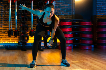 Obraz premium Health young woman make exercises with weight plates in gym.