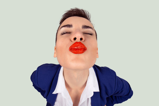 First kiss, unwanted kiss concept. Closeup portrait of nerdy young funny distorted woman face with big red lips eyes closed trying to kiss you camera, isolated light green white background