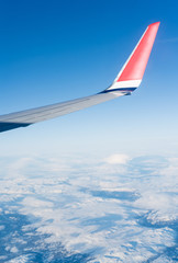 Fototapeta premium Wing aircraft in blue clear sky during flight