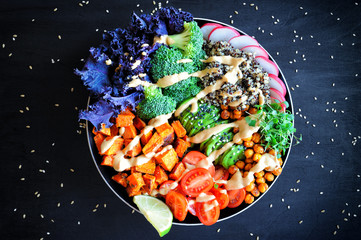 Fototapeta na wymiar Vegan Buddha bowl with quinoa, baked sweet potato and red kale leaves