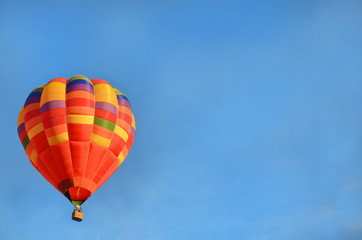multi-colored beautiful bright hot air balloon in the blue sky