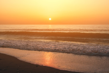 Beautiful orange sunset of the sea beach with rays of deep blue sky and sun