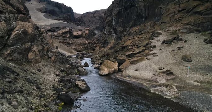 Drone shot of stream flowing amidst rock formations on mountain, Askja, Vatnajokull, Iceland