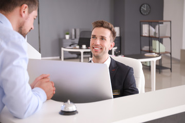 Male receptionist working with visitor in office