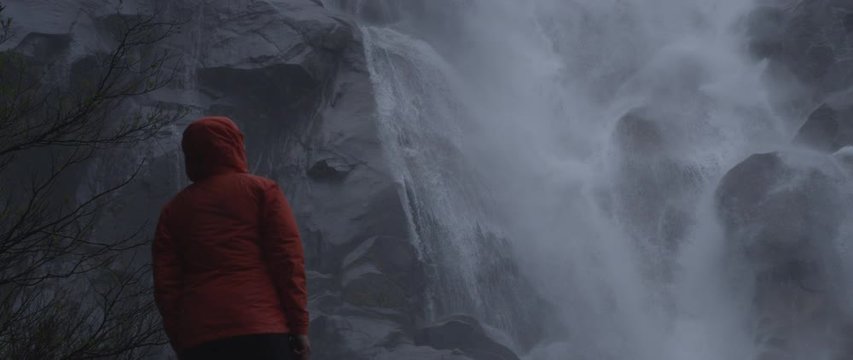 Female hiker standing below waterfall, Squamish, British Columbia, Canada