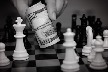 Closeup photo of a businessman playing with twisted dollars at a game of chess. A winning...