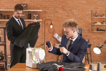 Young male tailor with colleague in atelier