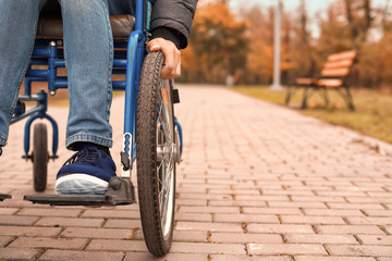 Handicapped young man in autumn park, closeup