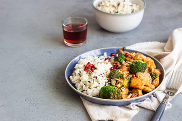 Curry chicken with rice, mushroom and broccoli decorated with pomegranate seeds. Healthy food. Asian cuisine.