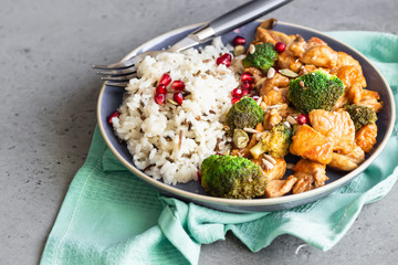 Curry chicken with rice, mushroom and broccoli decorated with pomegranate seeds. Healthy food. Asian cuisine.