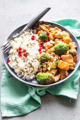 Curry chicken with rice, mushroom and broccoli decorated with pomegranate seeds. Healthy food. Asian cuisine.