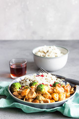 Curry chicken with rice, mushroom and broccoli decorated with pomegranate seeds. Healthy food. Asian cuisine.