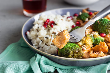 Curry chicken with rice, mushroom and broccoli decorated with pomegranate seeds. Healthy food. Asian cuisine.