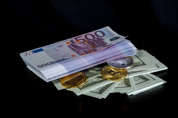a bundle of Euro hundred dollar bills and cryptocurrency coins on a black background
